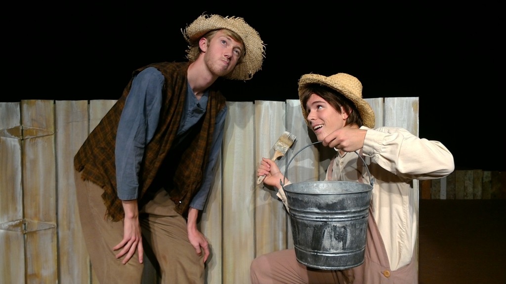 Tom Sawyer (William Van Nes) tries to persuade Huck Finn (Elijah Morgan) to help him paint the fence in ARIEL Theatrical's production of The Adventures of Tom Sawyer playing August 5, 6, 12,13, 19, & 20 at the Karen Wilson Children's Theatre in Salinas. photo credit: Stephen Massott